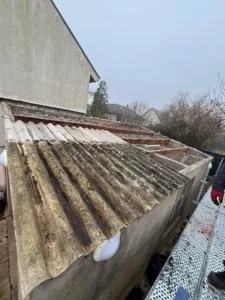Ancienne couverture en plaques ondulées sur une annexe avant les travaux