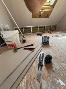 Outils et matériaux sur le plancher des combles en travaux