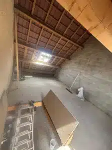 Combles bruts avec charpente apparente et tuiles vues de l’intérieur, avant aménagement