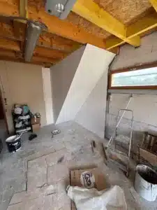 Combles en travaux avec cloisons et charpente apparente