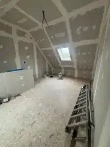 Pièce sous combles en plaques de plâtre avec fenêtre de toit