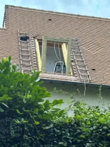Lucarne en construction dans la toiture en tuiles, échelles de couvreur