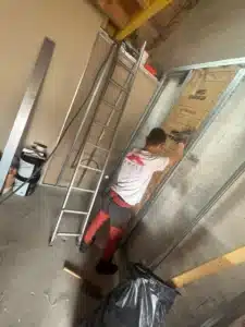 Ossature métallique et isolant en cours de pose le long d’un mur des combles